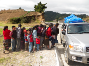 The children who wave along the CA-1 highway in Guatemala are lined up to receive a gift.