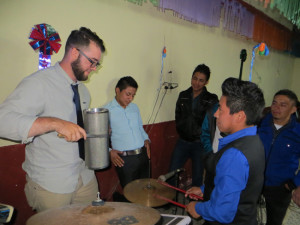 Team members learning to play the guiro -- a latin percussion instrument -- with the local worship band members..