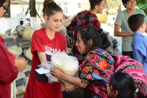 A team member sharing a bag of food with one of the mothers at the Christmas Party