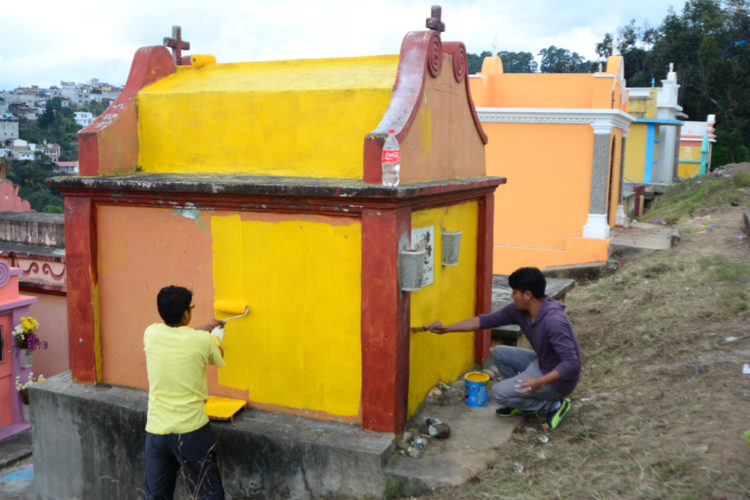 Painting tombs in the cemetery on All Saints Day.